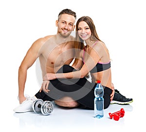 Athletic couple - man and woman after fitness exercise with dumb