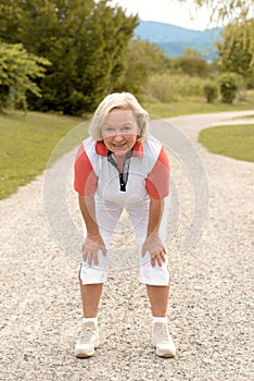 Athletic elderly woman working out on a rural road