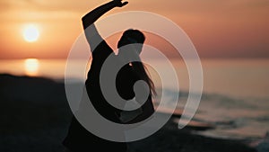 Athletic female silhouette practicing outdoor training at morning beach. Medium shot on RED camera