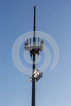 athletic field lights on a cell phone tower at sunset