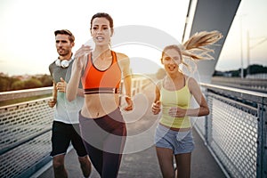 Athletic fit friends exercising and jogging together outdoors. Sport, friends, health concept