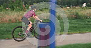 Athletic fit woman cyclist is cycling on road bike on promenade. Professional triathlete is training on bicycle and preparing for