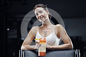 Athletic Fitness woman drinking water at workout in the gym