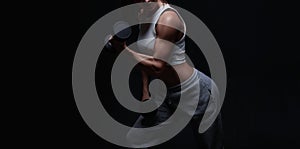 Athletic fitness woman posing in the studio on a dark background. Photo of an attractive woman in fashionable sportswear. Sports