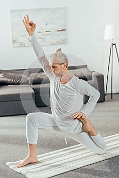 athletic flexible adult man practicing yoga on mat