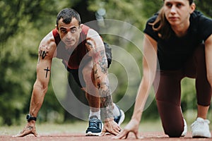 Athletic friends preparing for a sprint on a track surrounded by greenery