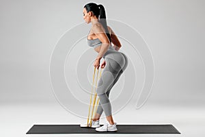 Athletic girl doing exercise with resistance band. Fitness woman working out