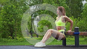 Athletic girl exercise the triceps on bench