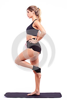 Athletic girl on a fitness mat on a light background