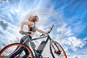 Athletic girl with hair flying in the wind leading electric bike