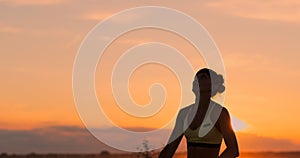 Athletic girl playing beach volleyball jumps in the air and strikes the ball over the net on a beautiful summer evening