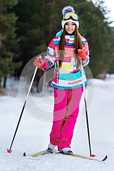 Athletic girl skiing in bright clothes
