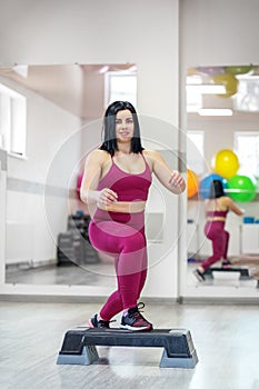 Athletic girl trains on stepper in the gym. The concept of sports, a healthy lifestyle, losing weight