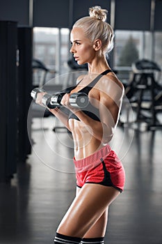 Athletic girl working out in gym. fitness woman doing exercise, muscular female