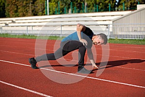Athletic guy doing stretching after jogging