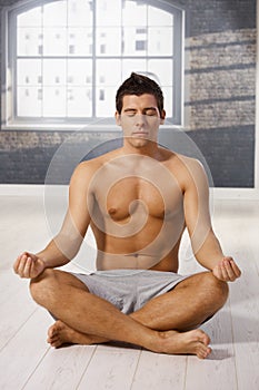 Athletic guy meditating