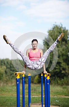 Athletic gymnast exercising on parallel bars