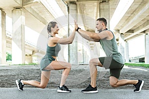 Athletic and happy couple doing lunges during street workout