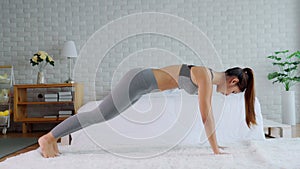 Athletic Healthy Asian woman in sportswear workout excercise at home