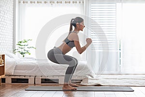 Athletic Healthy Asian woman in sportswear workout excercise at home