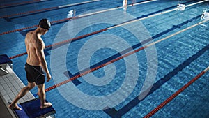 Athletic Male Swimmer Stands on a Starting Block, Ready to Dive into Swimming Pool. Determined