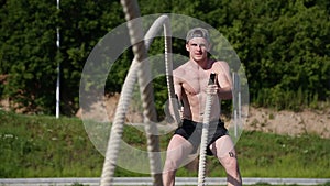 Athletic Male Working Out Using Battle Ropes. Crossfit.