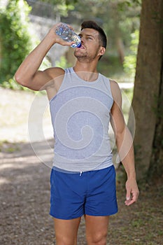 Athletic man in 30s resting and drinking