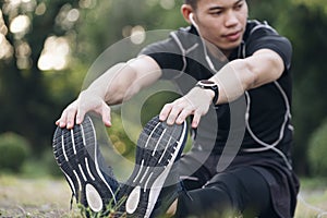 Athletic man in black sportswear doing fitness stretching exercises.