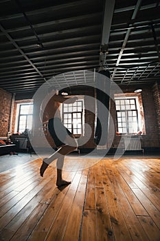 An athletic man boxer training with a punching bag in the gym. Man about to kick the bag with a leg