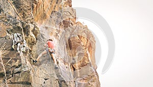 Athletic man climbing a rock wall at sunset - Climber performing on a canyon mountain