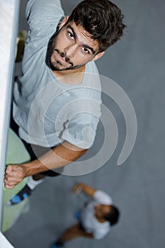 Athletic man climbing up wall