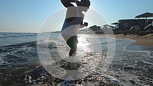 Athletic man doing gymnastics on the sea early in the morning