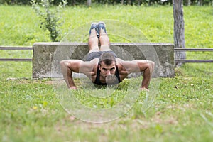 Athletic man doing push ups, outdoor.