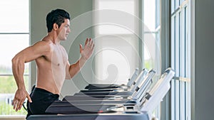 Athletic man doing running exercise on treadmill in gym and fitness center