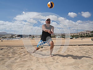 Athletic man dredges the beachvolleyball