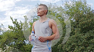 Athletic man drinking clean water from a bottle