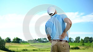 Athletic man golfer suffering sharp lower back pain, sport trauma, health