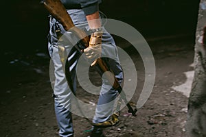 Athletic man in gray clothes with a carbine gun in his hand