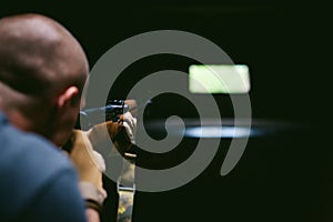 Athletic man in gray clothes with a carbine gun in his hand