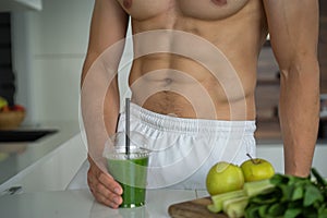 Athletic man holding a green smoothie