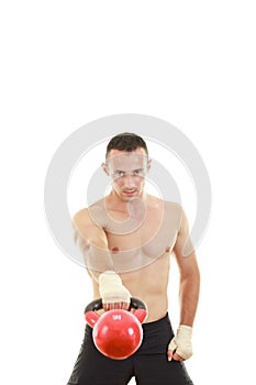 Athletic man holding and lifting up red kettlebell weight