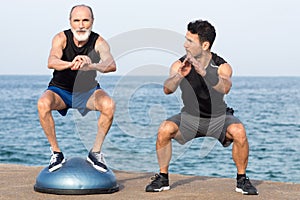 Athletic man making a step exercise with coach on balance platform