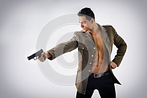 Athletic Man in Open Military Jacket Holding Gun