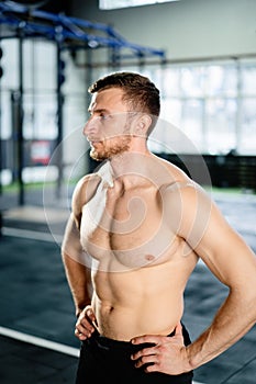 Athletic man posing hardcore in the gym