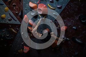 Athletic man practicing in a bouldering gym photo