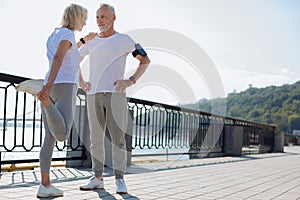 Athletic man providing balance for woman doing stretching exercises