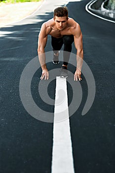 Athletic Man Ready To Start Running Outdoors. Sports Workout Concept