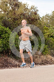 Athletic man runner jogging in nature outdoor