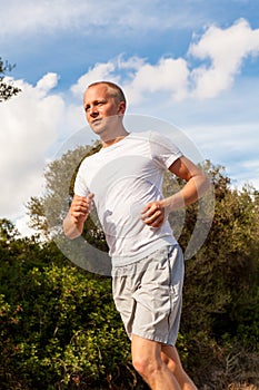 Athletic man runner jogging in nature outdoor