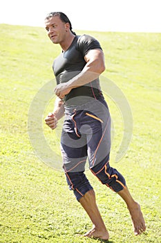 Athletic man running in the field